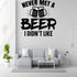 a wall with a humorous text that reads "NEVER MET A BEER I DIDN'T LIKE" in bold letters. Below the text, there are two beer mugs with a celebratory design. The wall is set against a white marble background, and there is a gray couch with two white pillows in the foreground. A coffee table is also present in the room.
