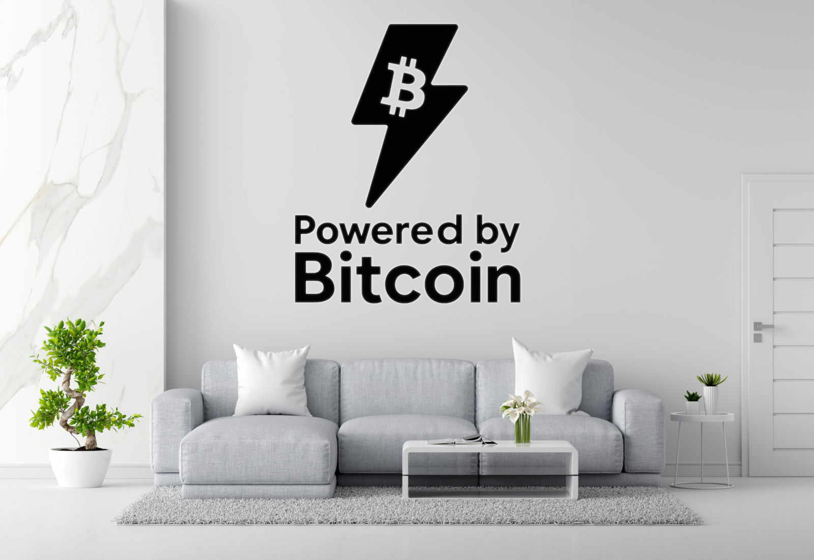 a living room with a gray sofa, a coffee table, and a potted plant. Above the sofa, there is a wall decal that says "Powered by Bitcoin".