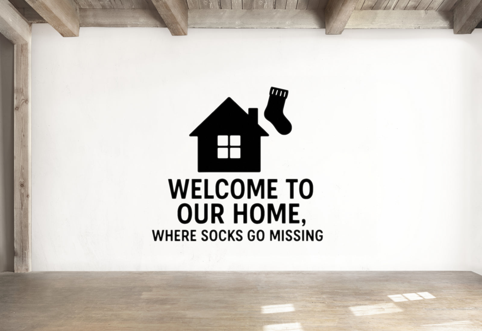 a wall with a black and white graphic of a house and a sock, along with the text "WELCOME TO OUR HOME, WHERE SOCKS GO MISSING".