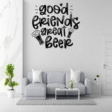 a living room with a gray sofa, a coffee table, and a potted plant. Above the sofa, there is a wall decoration with the text "Good friends great beer" in a stylized font.