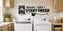 Black Wash Dry Start Fresh laundry room wall decal with washer, shirt, and sparkle details above white laundry machines.