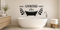 Black Soak Unwind Reset bathroom wall decal with bathtub, steam, and eucalyptus above a white freestanding tub.