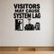 Visitors May Cause System Lag removable vinyl wall decal shown in a styled room.