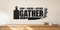 Black Chop Savor Gather kitchen wall decal with cutting board, chef knife, and herb sprig above a light oak sideboard.