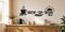 Black Brew Sip Begin coffee bar wall decal with steaming mug, beans, spoon, saucer, and sunrise above a wood cabinet.