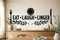 EAT LAUGH LINGER black vinyl dining room wall decal with plate, fork, knife, and olive branches above a pale oak sideboard.