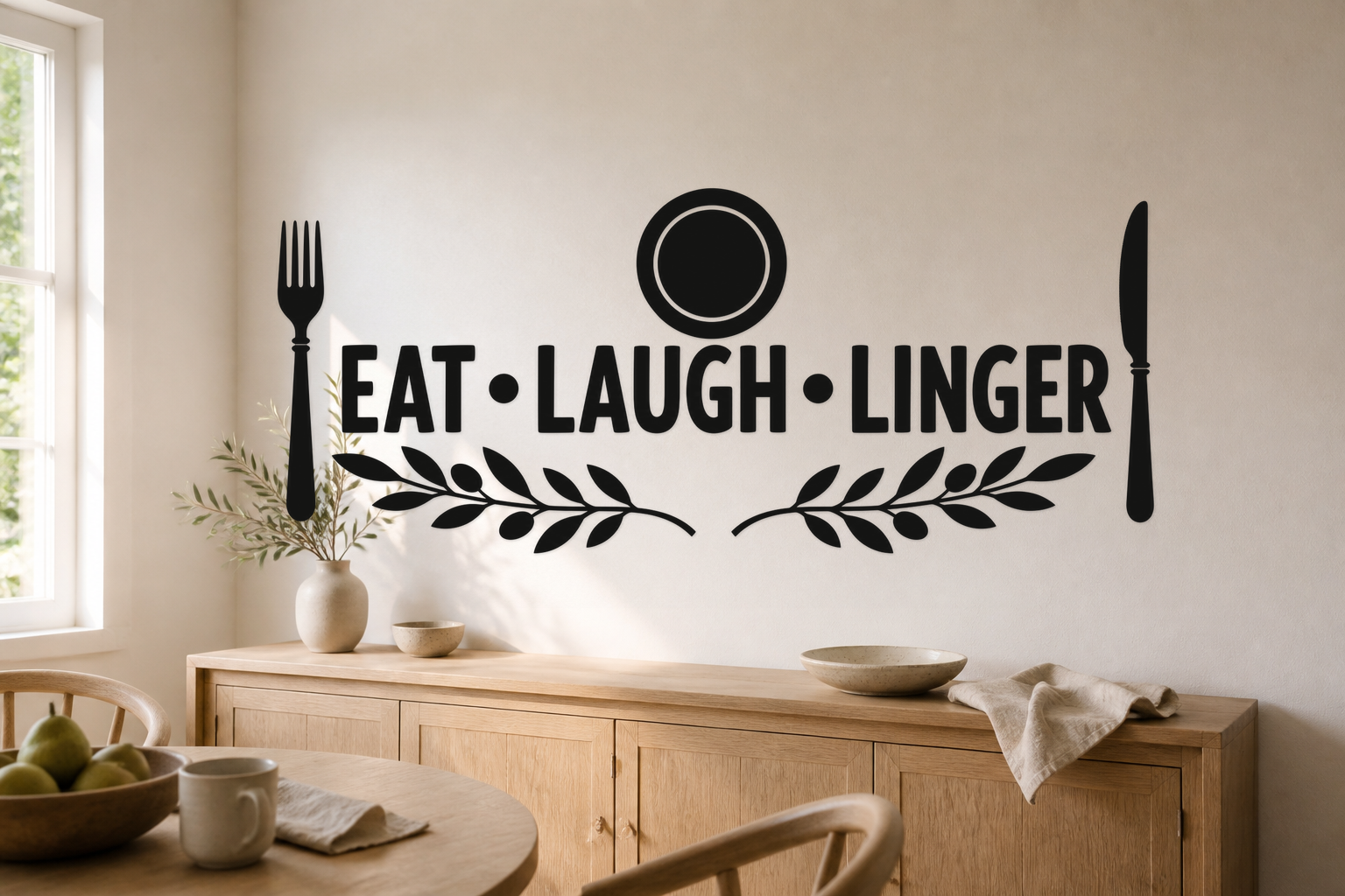 Exact EAT LAUGH LINGER matte black dining wall decal in a bright breakfast nook with plate, utensils, and olive branches.