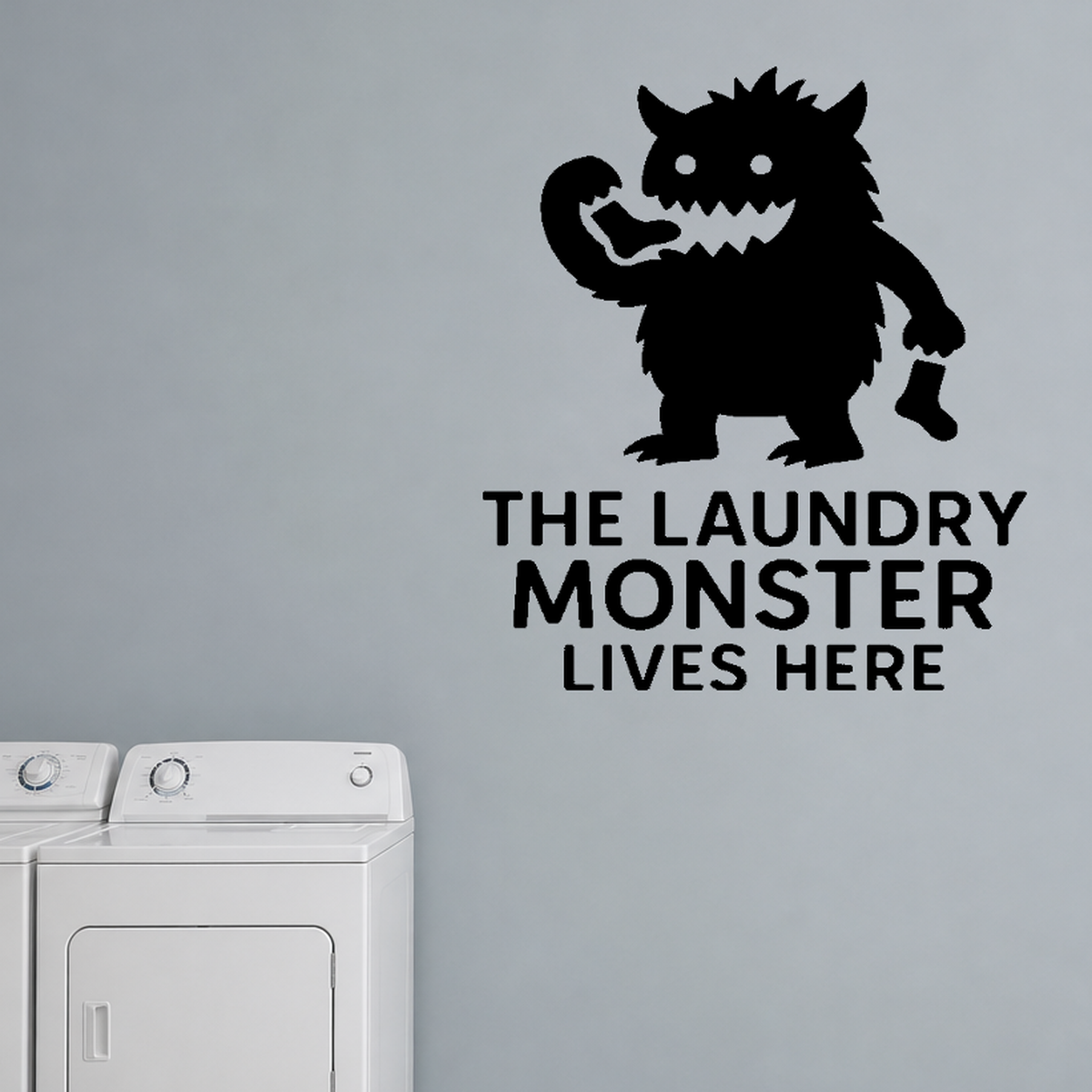 The Laundry Monster Lives Here - Funny Laundry Room removable vinyl wall decal shown on a smooth interior wall