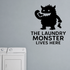 The Laundry Monster Lives Here - Funny Laundry Room removable vinyl wall decal shown on a smooth interior wall