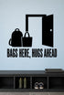 Bags Here, Hugs Ahead removable vinyl wall decal shown in a mudroom / entryway setting.