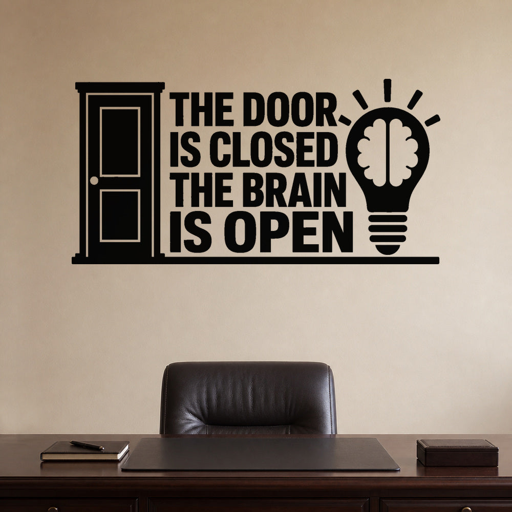 The Door Is Closed The Brain Is Open removable vinyl wall decal shown on a smooth home office wall
