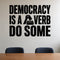 Democracy Is a Verb Do Some removable vinyl wall decal shown in a styled room.