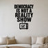 Democracy Is Not a Reality Show removable vinyl wall decal shown in a styled room.