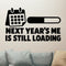 Next Year's Me Is Still Loading Removable Wall Decal shown on a clear indoor wall