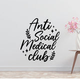 a wall with a large black text that reads "Anti Social Medical club" surrounded by decorative elements such as leaves and stars.