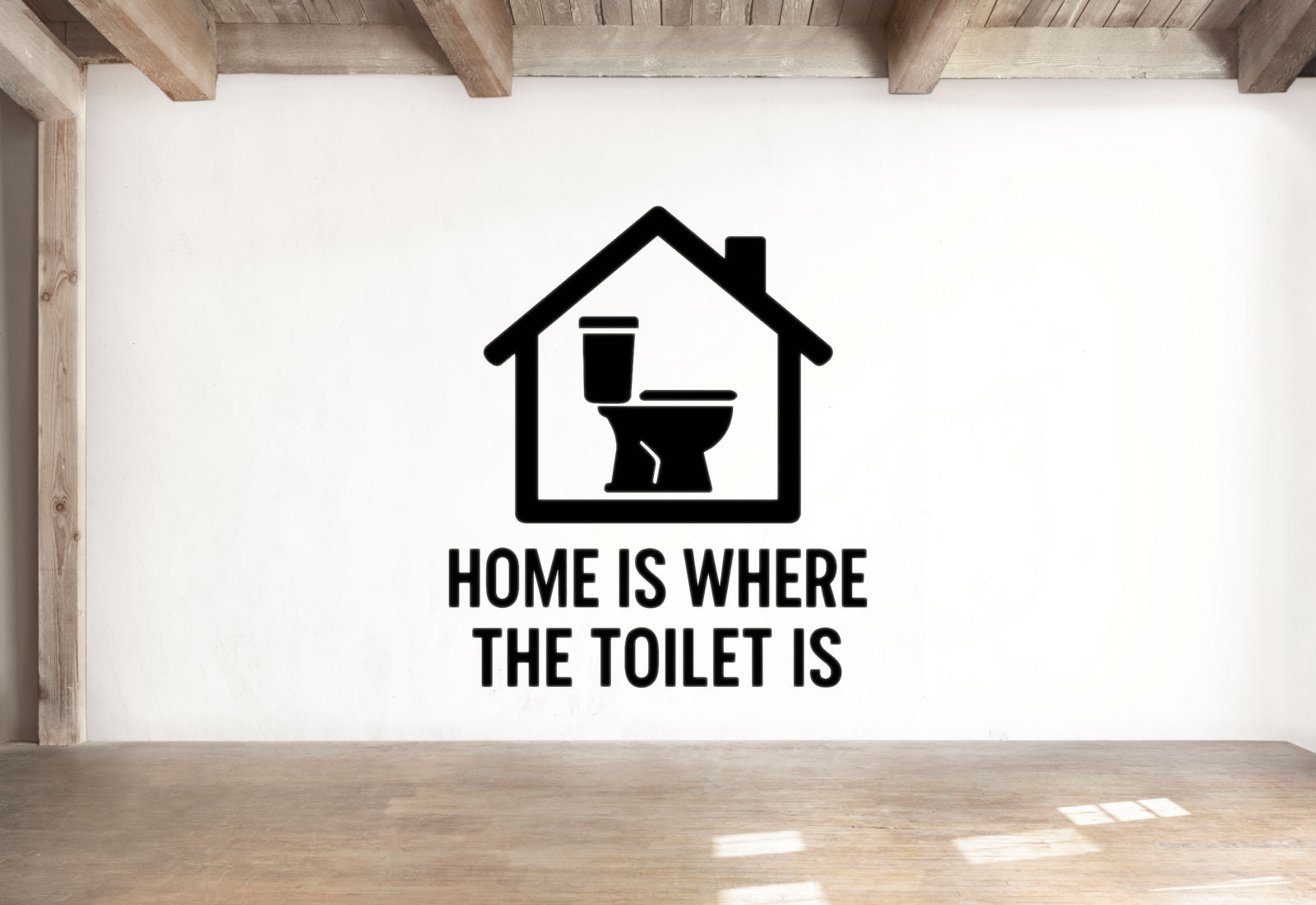 a wall with a black and white graphic of a house with a toilet inside, accompanied by the text "HOME IS WHERE THE TOILET IS" below the graphic.