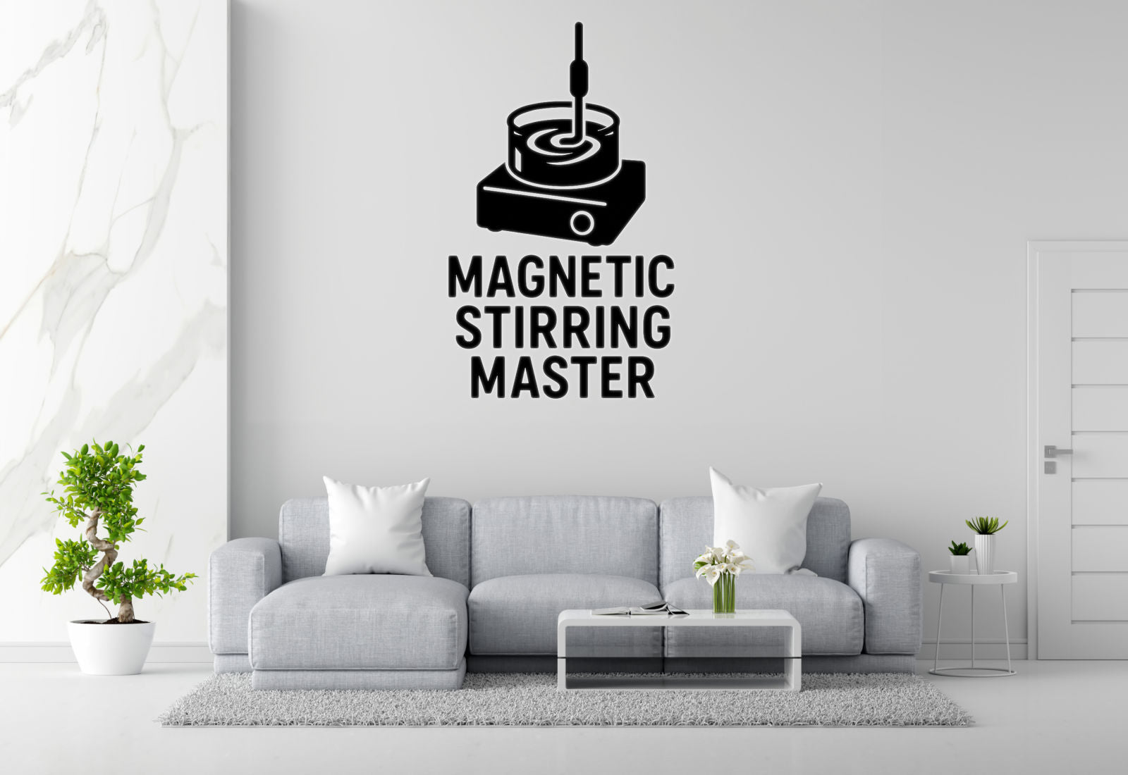 a living room with a gray sofa, a coffee table, and a potted plant. Above the sofa, there is a wall decal that says 