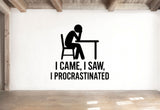 a wall with a simple black and white graphic of a person sitting at a table, accompanied by the text "I CAME, I SAW, I PROCRASTINATED" below the graphic.