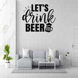 a living room with a gray sofa, a coffee table, and a potted plant. Above the sofa, there is a wall decoration that says "Let's drink beer" with a beer mug icon.